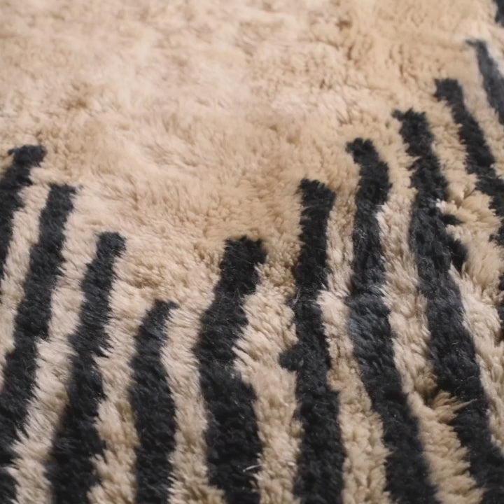Close-up of Wavy Striped Moroccan Wool Rug, handmade with black and ivory stripes, perfect for boho or modern homes.