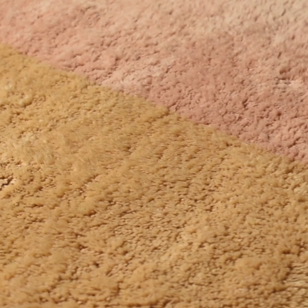 Close-up of a handwoven Moroccan wool rug in pink and beige tones, showcasing intricate berber patterns. Perfect for any elegant space.