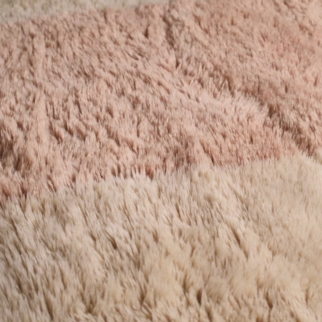 Close-up of minimalist Moroccan wool rug with peach and cream stripes. Handmade for elegant, cozy interiors. Moroccan rug.