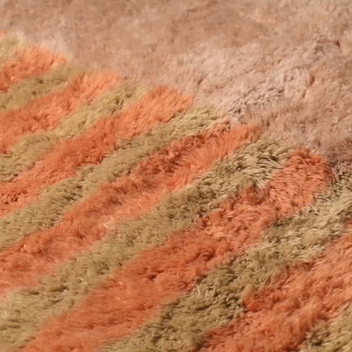 Close-up of a Moroccan Beni Mrirt rug with earthy orange and beige stripes, showcasing premium wool texture and Berber craftsmanship.