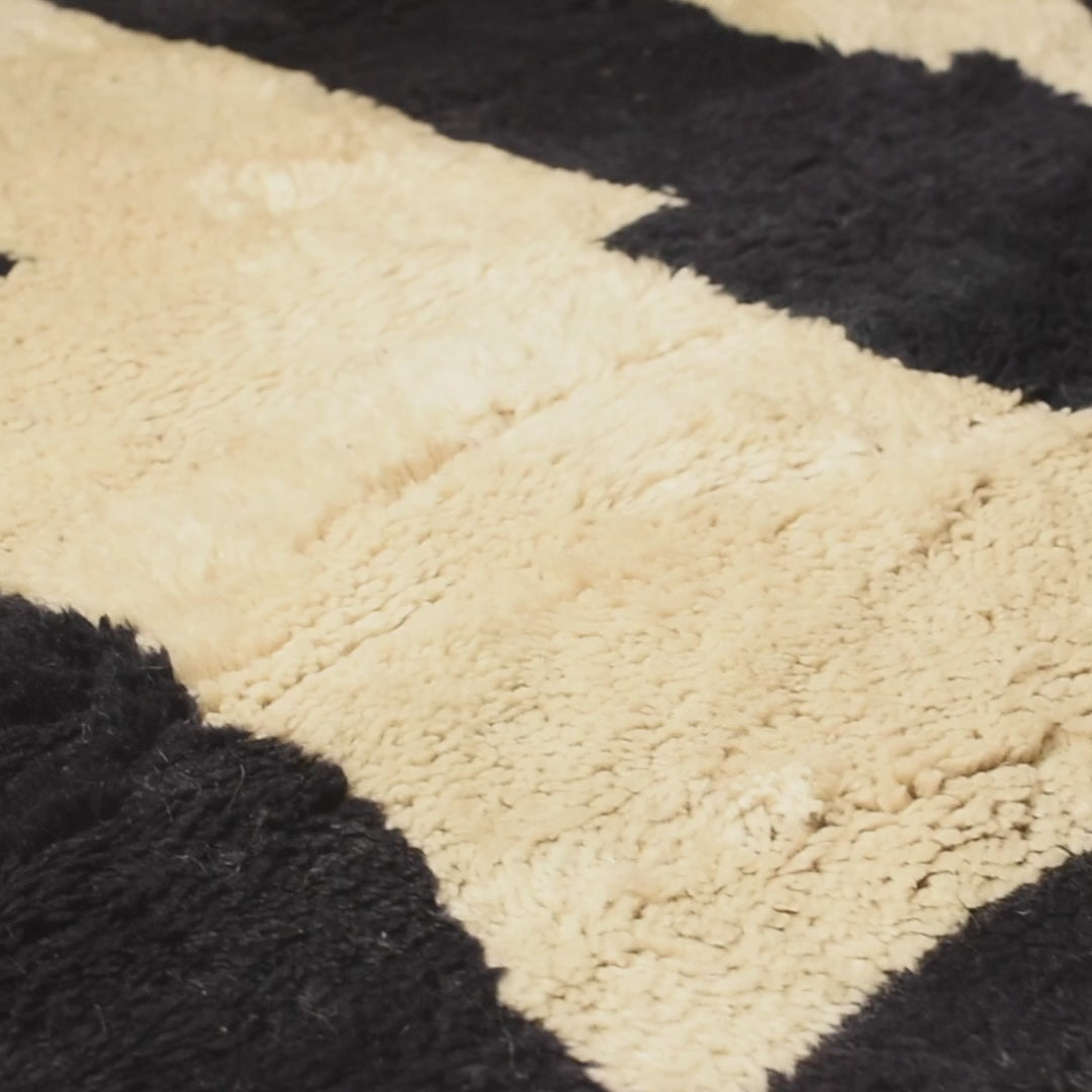 Abstract black and cream Moroccan Beni Mrirt wool rug with geometric pattern. Luxurious and handcrafted for modern interiors.