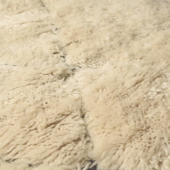 Close-up of cream Moroccan Berber rug texture, featuring soft wool. Ideal for adding a touch of elegance and warmth.