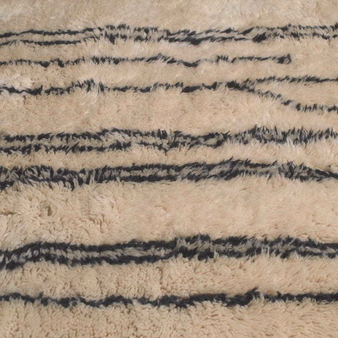 Handmade Moroccan wool rug with abstract black linear design, ideal for modern interiors. Plush comfort, traditional Berber style.