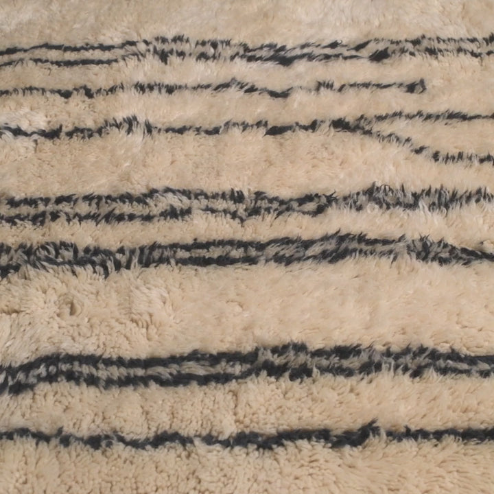 Handmade Moroccan wool rug with abstract black linear design, ideal for modern interiors. Plush comfort, traditional Berber style.