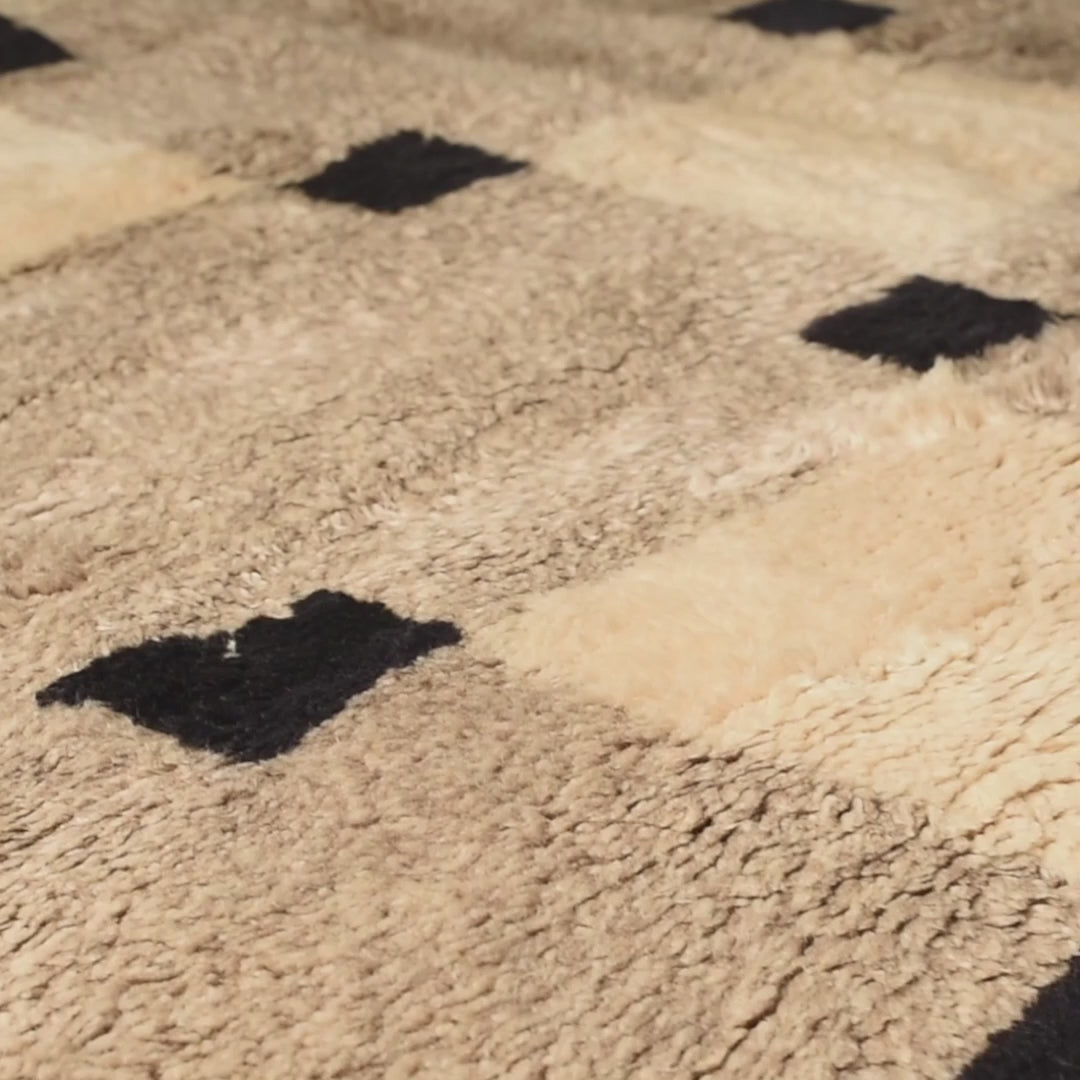 Minimalist checkered Moroccan Berber rug in black and cream, handwoven wool, perfect for modern interiors.