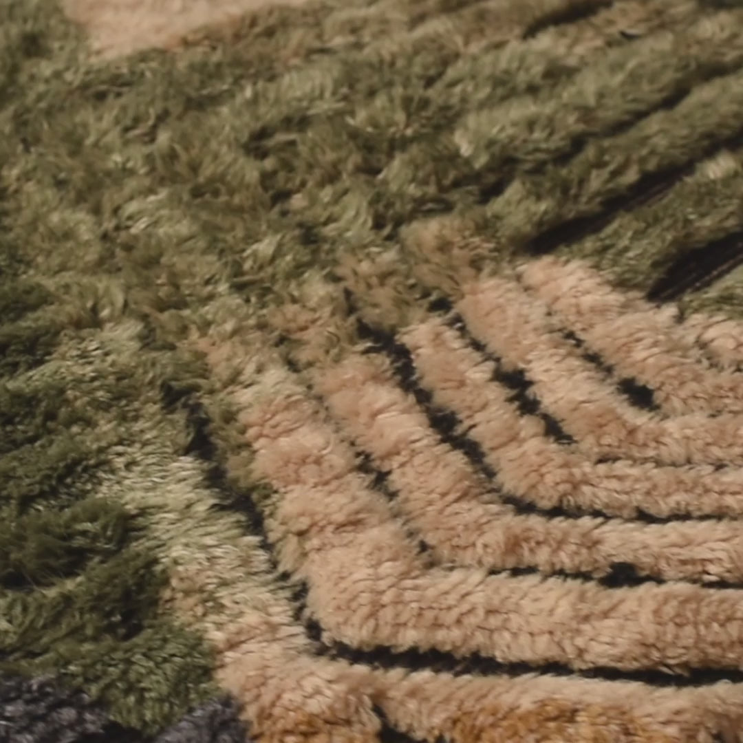 Close-up of a Geometric Moroccan Wool Rug with hand-knotted triangles and stripes in green, cream, and ochre.