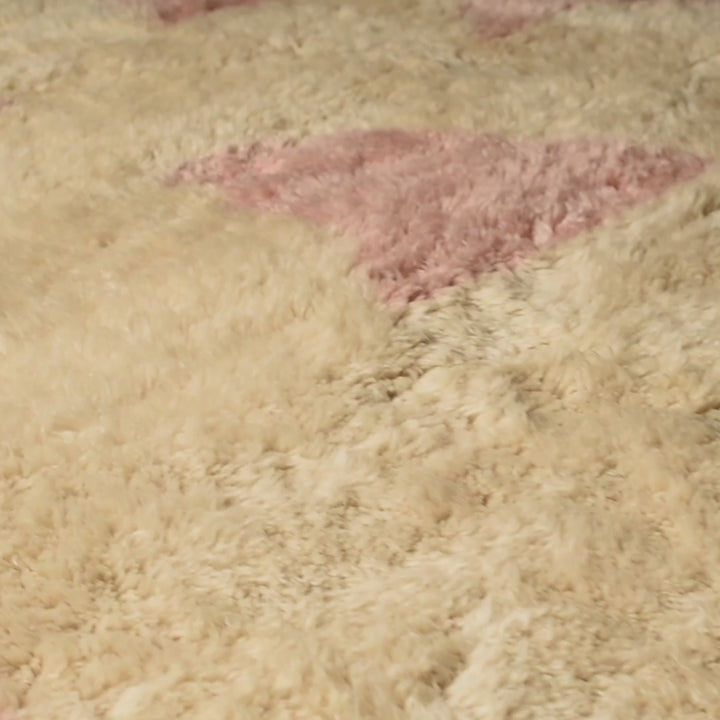 Soft pink geometric wool Moroccan rug with ivory base, showcasing playful abstract design and traditional craftsmanship.