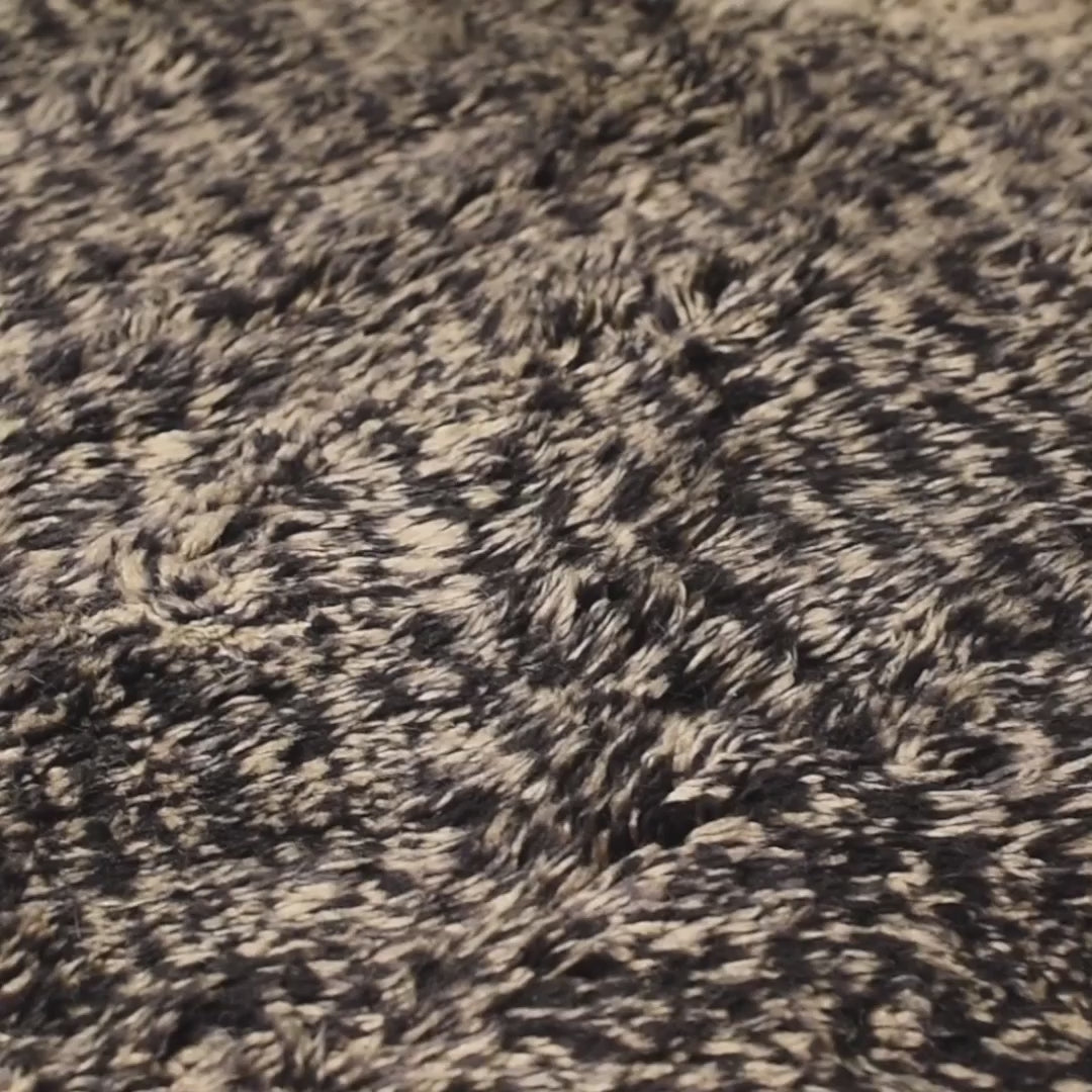 Close-up of a Handmade Beni Mrirt Moroccan wool rug in black and ivory, featuring a plush and textured design.