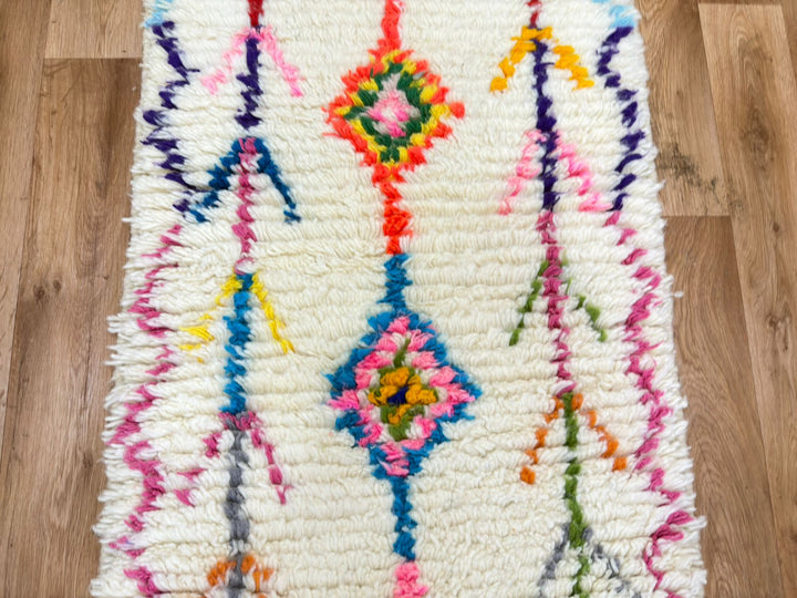 Colorful woven rug with geometric patterns on a wooden floor