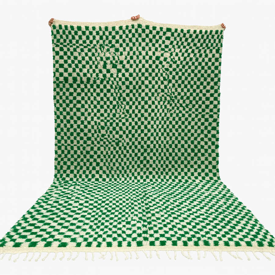 Green and white checkered rug with tassels on a white background