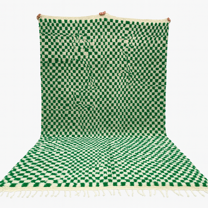 Green and white checkered rug with tassels on a white background