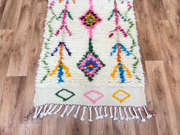 Colorful woven rug with geometric patterns on a wooden floor