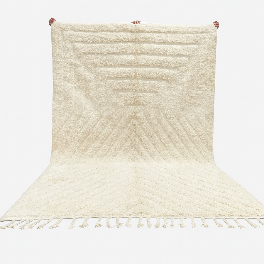 Beige woven rug with a chevron pattern on a white background