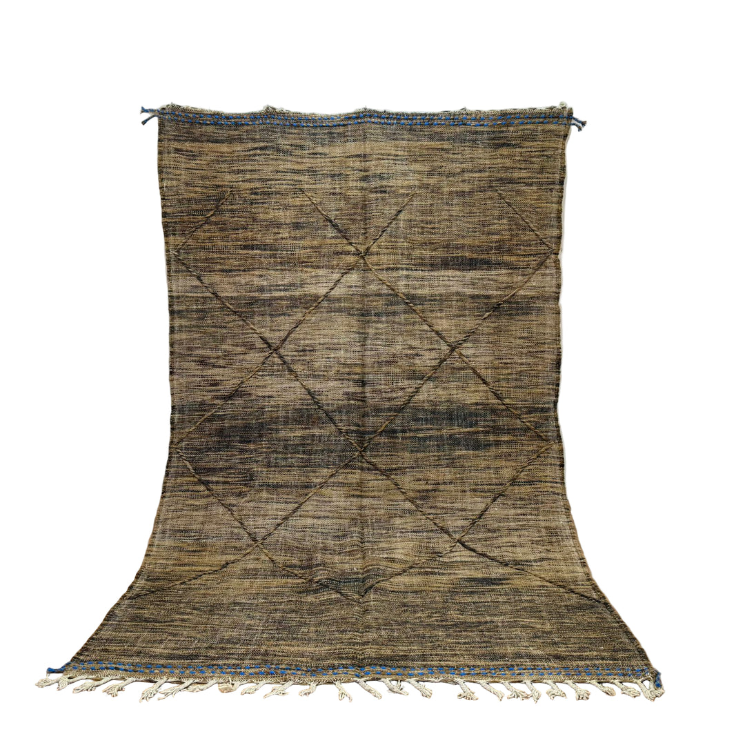 Textured rug with geometric pattern on a wooden floor against a white wall