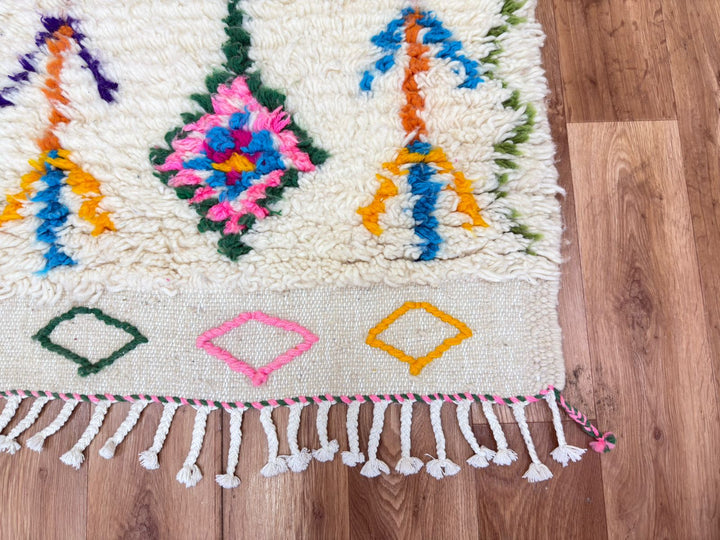 Colorful woven rug with geometric patterns on a wooden floor