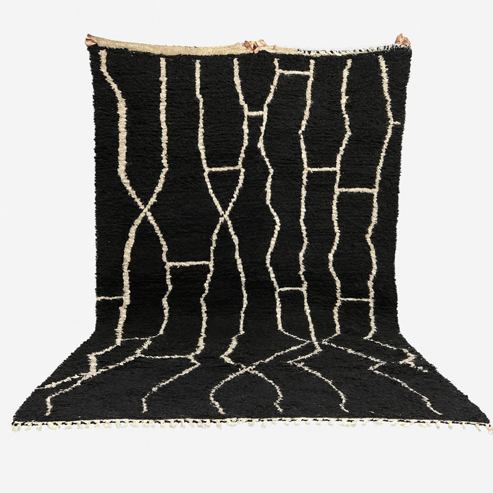 Black rug with white geometric patterns on a white background