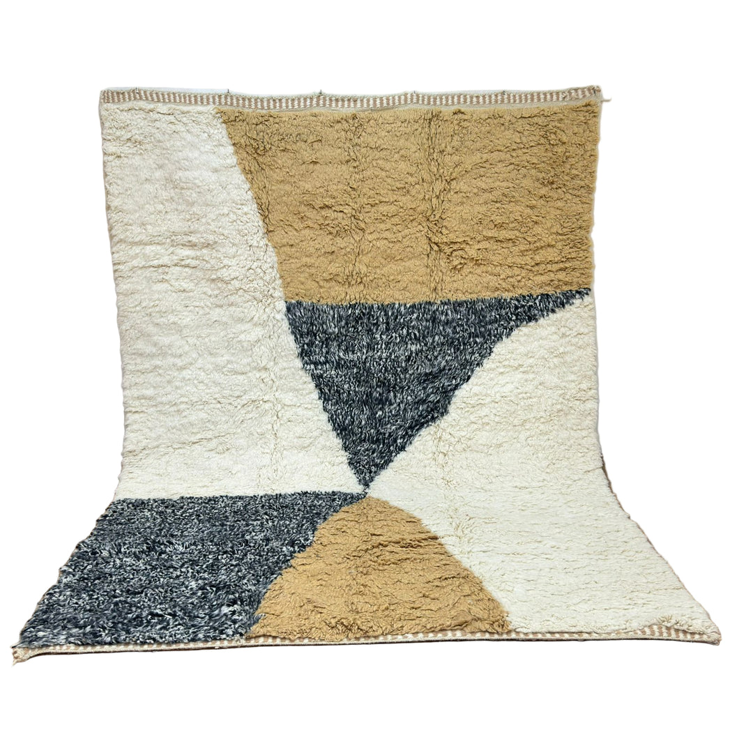 Geometric patterned rug with beige, brown, and blue triangles on a wooden floor.