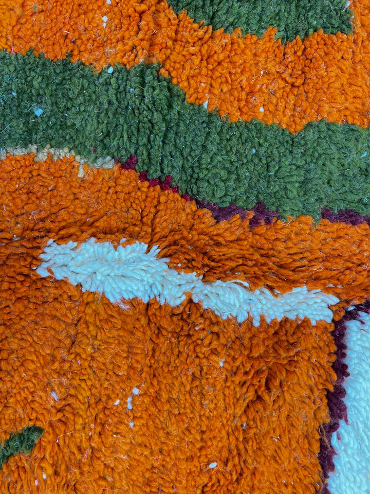 Handmade colorful abstract Moroccan wool runner rug with blue, orange, green, mustard, and cream geometric shapes.
