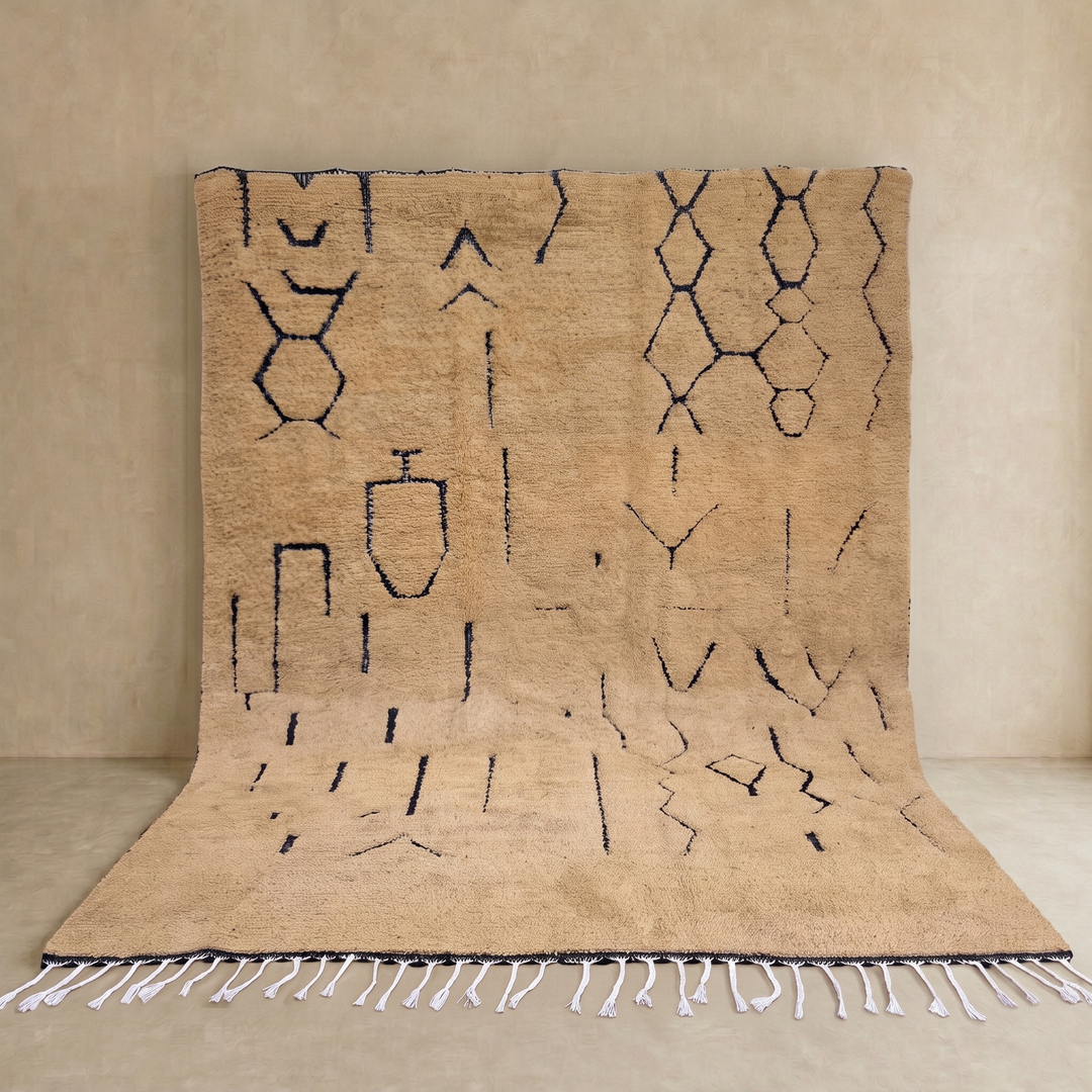 Handmade beige Moroccan wool rug with black abstract Berber symbols and white tassels
