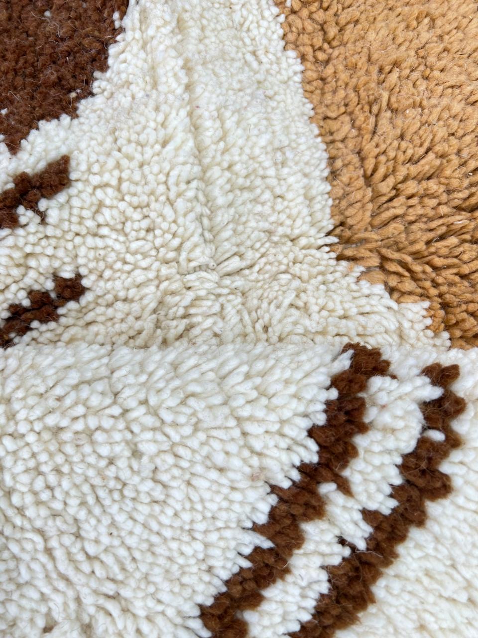 Round Moroccan abstract rug with brown, beige, and cream geometric shapes and artistic line details.