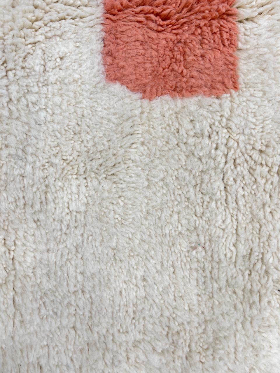 Round Moroccan wool rug with modern abstract design in brown, peach, and white.