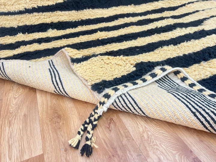 Abstract Moroccan wool rug in beige with black line pattern, handwoven by Berber artisans. Perfect as a contemporary area rug.