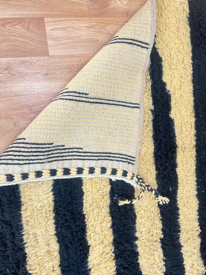 Abstract Moroccan wool rug in beige with black line pattern, handwoven by Berber artisans. Perfect as a contemporary area rug.