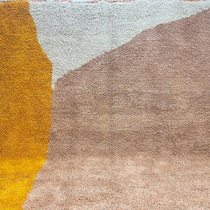 Abstract earth tone round Moroccan wool rug with mustard, ivory, and clay color-block design, handmade plush Berber shag area rug