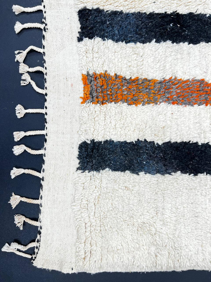 Handmade ivory Moroccan wool rug with orange, black, yellow, and gray abstract stripe patterns – modern Berber rug