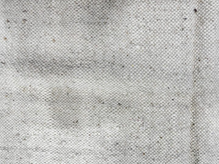 Abstract round Moroccan kilim rug with flatweave wool design in white, black, and teal.