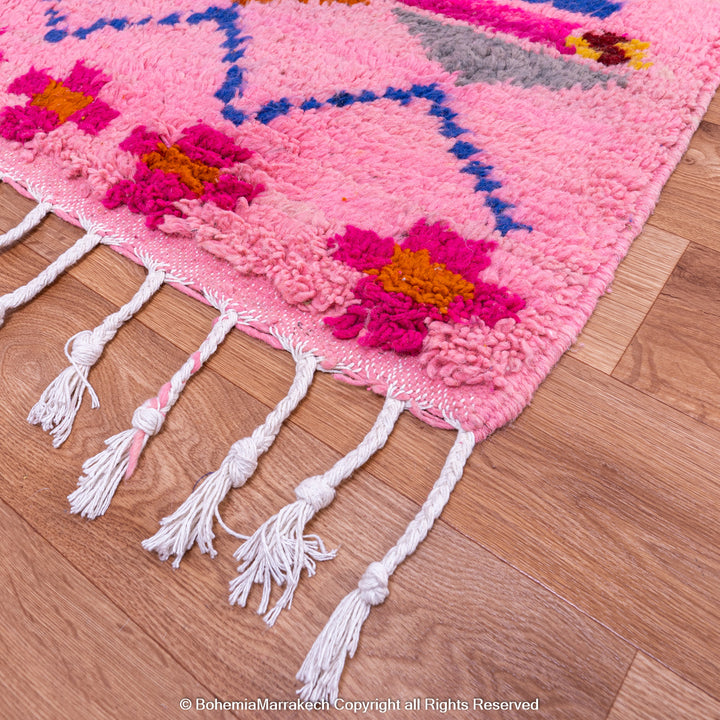 Pink handmade Boujaad Moroccan rug with multicolored tribal symbols and geometric patterns