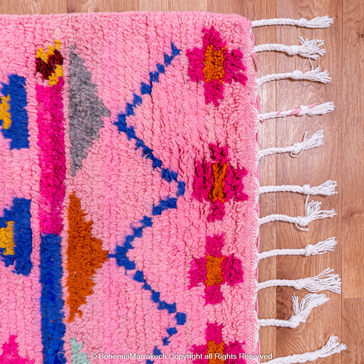 Pink handmade Boujaad Moroccan rug with multicolored tribal symbols and geometric patterns
