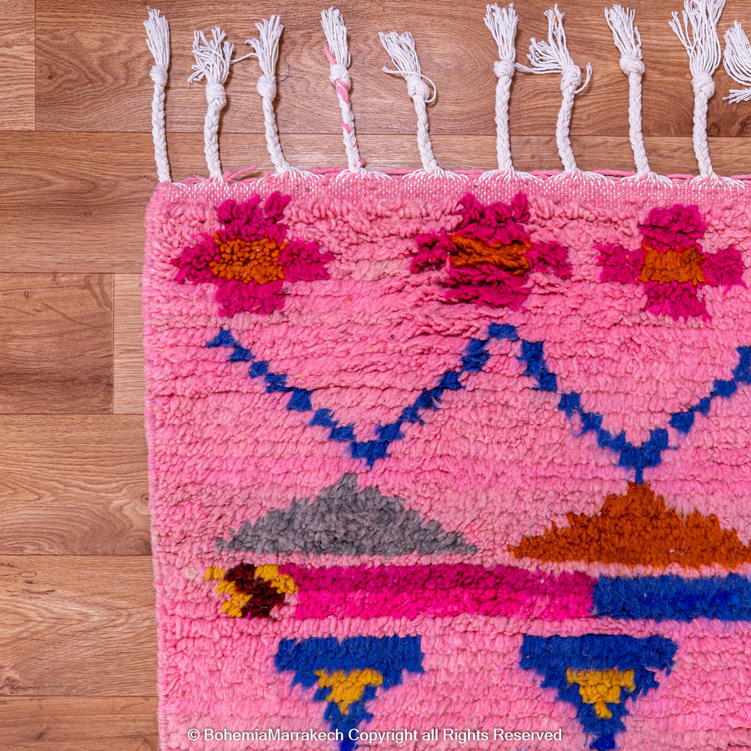 Pink handmade Boujaad Moroccan rug with multicolored tribal symbols and geometric patterns