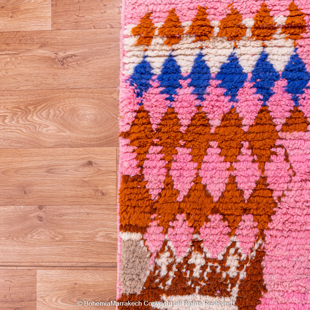Pink handmade Boujaad Moroccan rug with multicolored tribal symbols and geometric patterns
