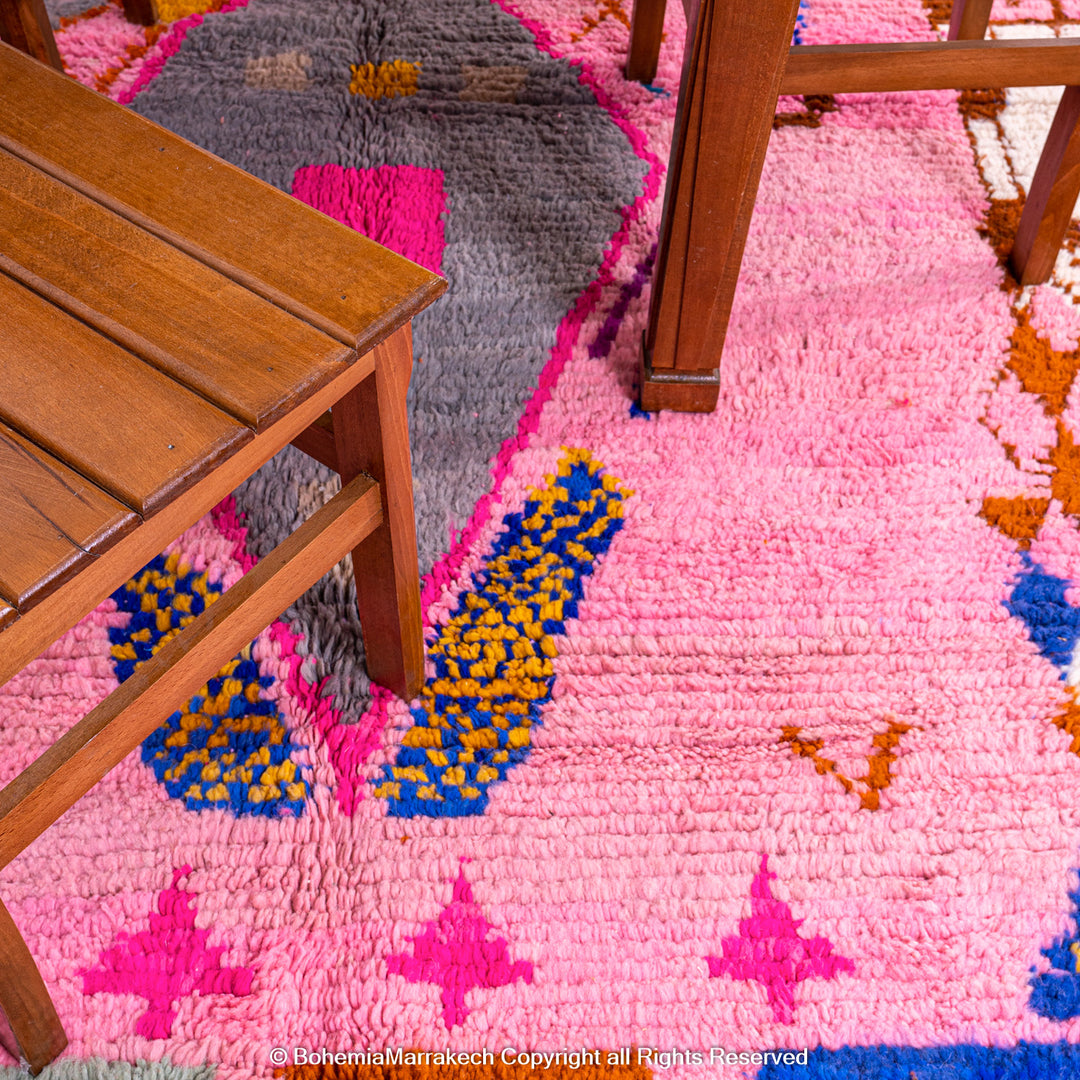 Pink handmade Boujaad Moroccan rug with multicolored tribal symbols and geometric patterns