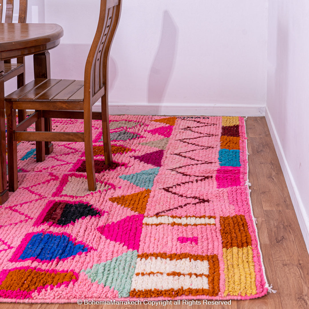 Pink handmade Boujaad Moroccan rug with multicolored tribal symbols and geometric patterns