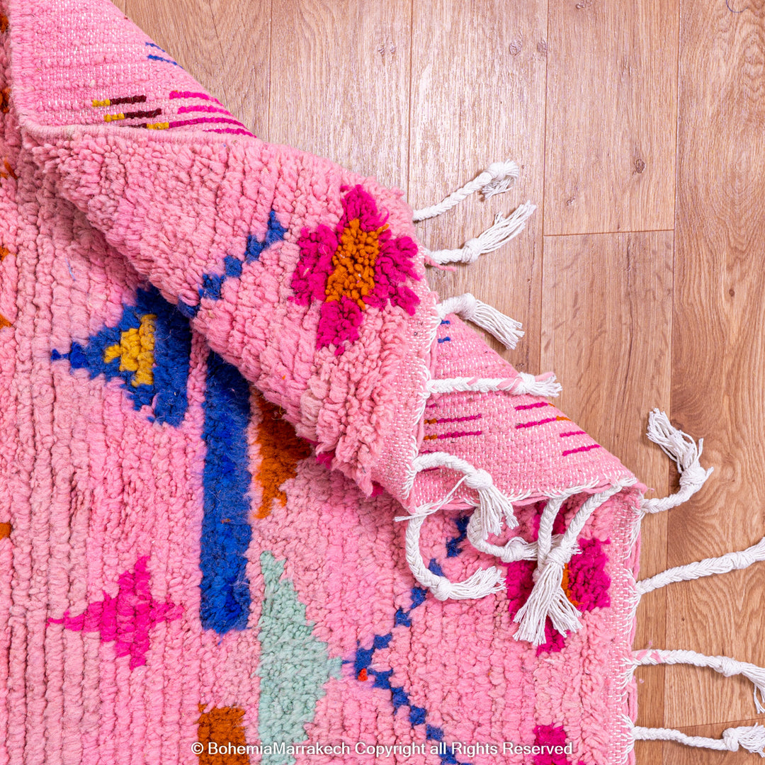 Pink handmade Boujaad Moroccan rug with multicolored tribal symbols and geometric patterns