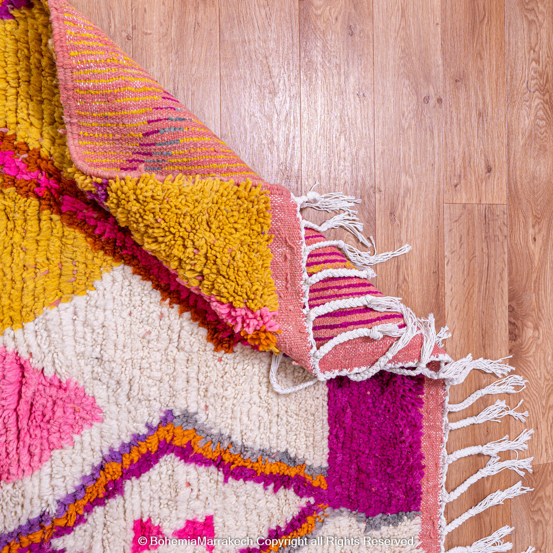 Multicolored Moroccan Boujaad Rug handmade with wool, featuring vibrant pink, yellow, and blue Berber patterns.