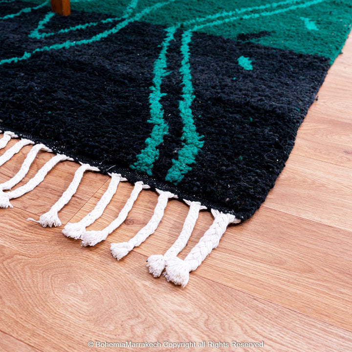 Green Moroccan Boujaad rug with black Berber motifs, handmade in wool by artisans in Morocco