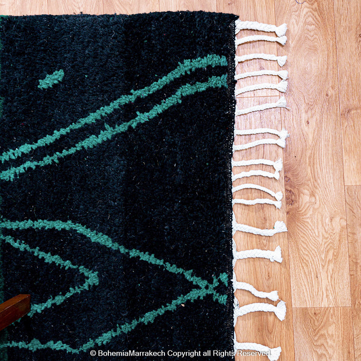 Green Moroccan Boujaad rug with black Berber motifs, handmade in wool by artisans in Morocco