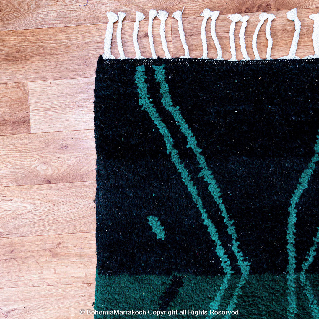 Green Moroccan Boujaad rug with black Berber motifs, handmade in wool by artisans in Morocco