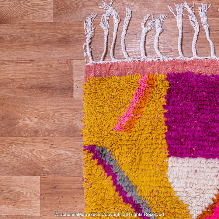 Multicolored Moroccan Boujaad Rug handmade with wool, featuring vibrant pink, yellow, and blue Berber patterns.