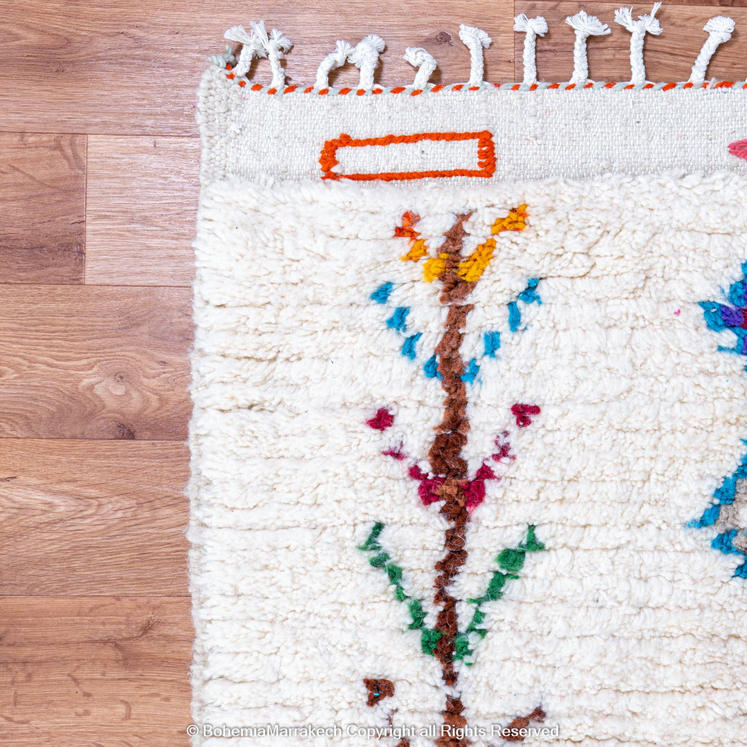 Handmade Beni Ourain Moroccan wool rug with colorful Berber diamonds on a white shag background