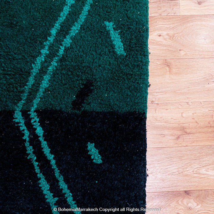 Green Moroccan Boujaad rug with black Berber motifs, handmade in wool by artisans in Morocco