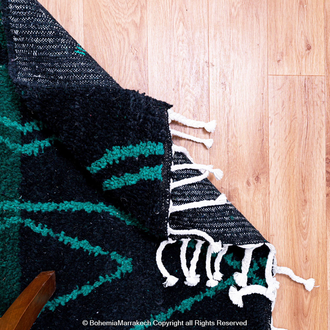 Green Moroccan Boujaad rug with black Berber motifs, handmade in wool by artisans in Morocco