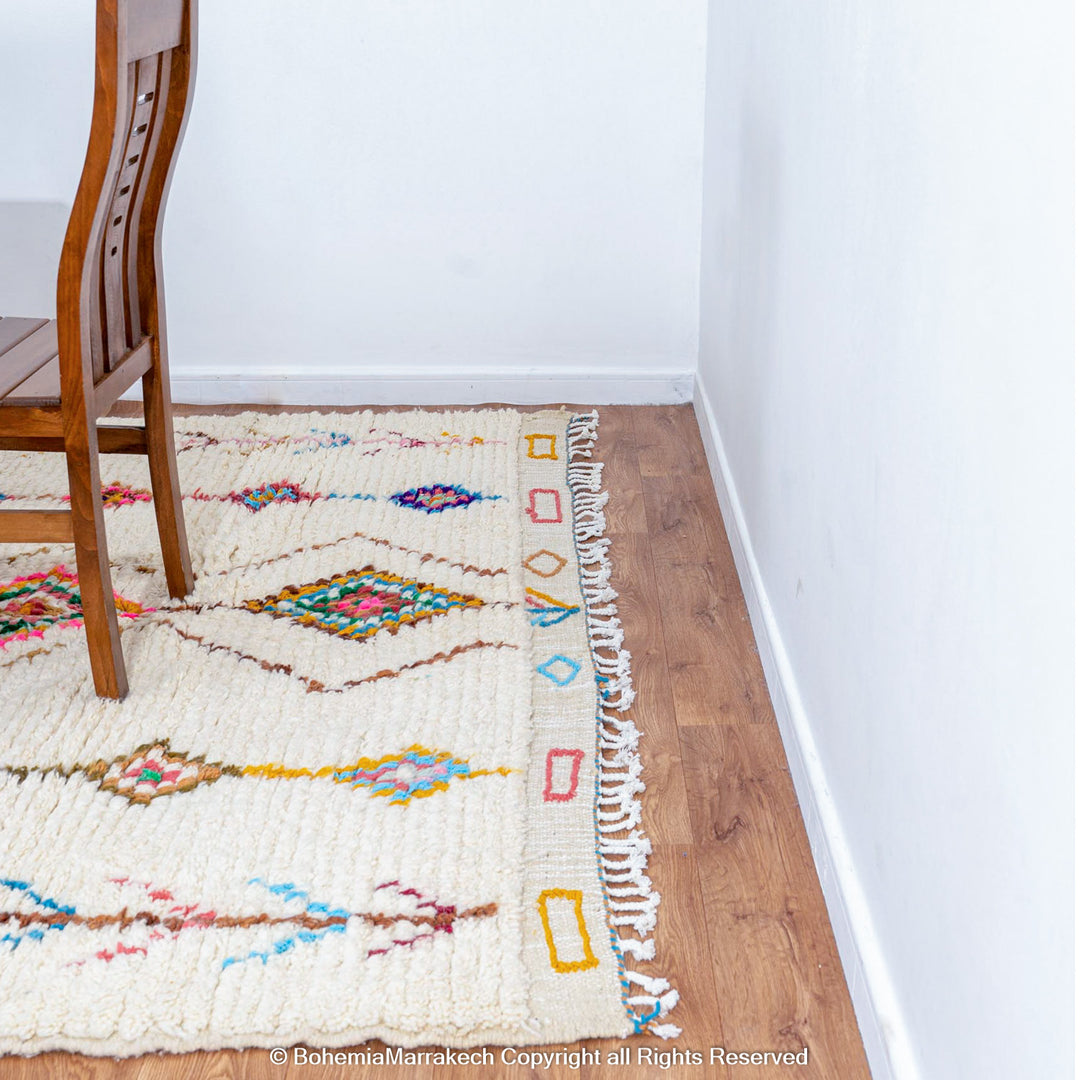 Handmade Beni Ourain Moroccan wool rug with colorful Berber diamonds on a white shag background
