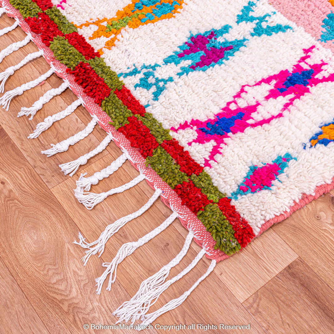 Handmade pink Boujaad Moroccan rug with colorful tribal and diamond motifs on wool