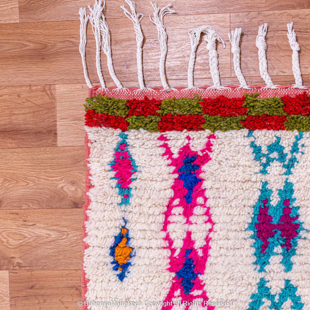 Handmade pink Boujaad Moroccan rug with colorful tribal and diamond motifs on wool
