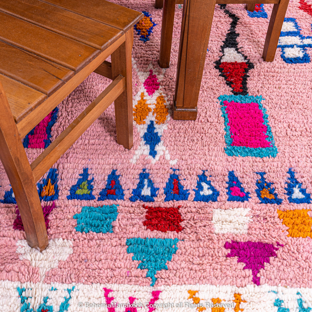 Handmade pink Boujaad Moroccan rug with colorful tribal and diamond motifs on wool