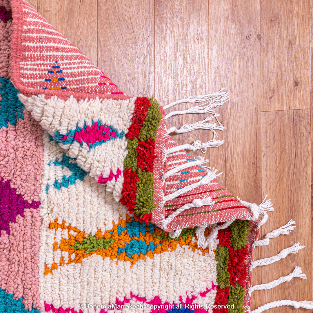 Handmade pink Boujaad Moroccan rug with colorful tribal and diamond motifs on wool